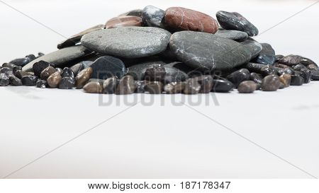 Stacked Rocks on a white background with color rocks on top