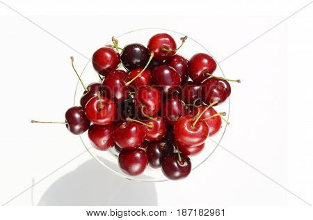 Fresh ripe red cherries berries in crystal vase on a white background top view picture