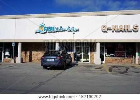 BAY VIEW, MICHIGAN / UNITED STATES - NOVEMBER 26, 2016: One may have one's hair cut and one's skin tanned, and enjoy a massage, at the Fiji Salon and Spa, in a Bay View strip mall.