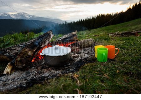 On the bonfire in the pot cooking on the nature