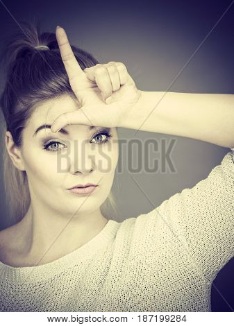 Woman Showing Loser Gesture With L On Forehead