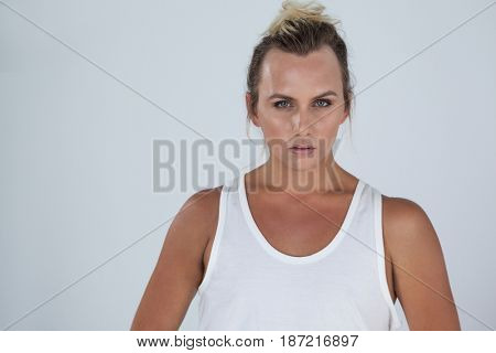 Portrait of beautiful transgender woman standing over gray background