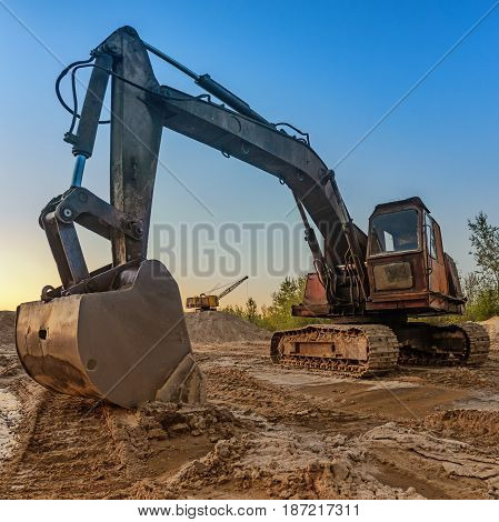 The old excavator with a large bucket extracts sand in a quarry. Ukraine