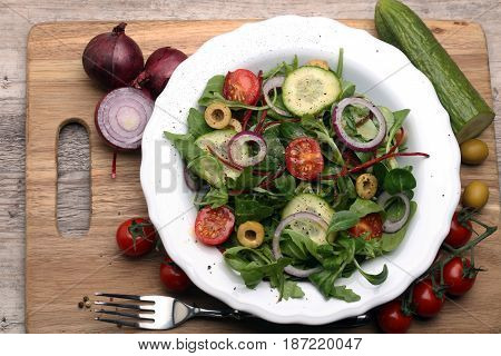Caprese. Caprese salad. Italian salad. Mediterranean salad. Italian cuisine. Mediterranean cuisine. Tomato mozzarella basil leaves black olives and olive oil on wooden table. Recipe - Ingredients