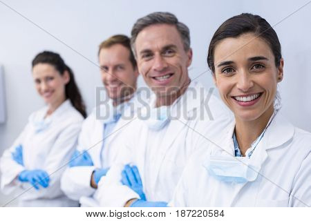 Portrait of smiling dentists standing with arms crossed in dental clinic