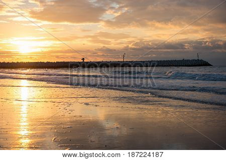 Sunset at the pier at the North Sea beach of Cadzand Holland