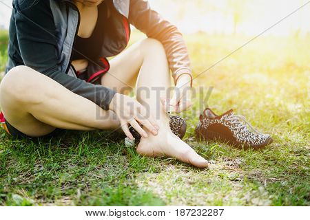 Sporty woman treating her foot ankle. Injury
