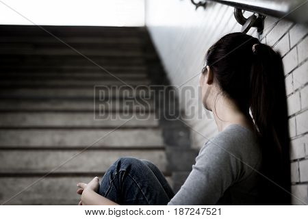 depressed woman sit and look somewhere in underground
