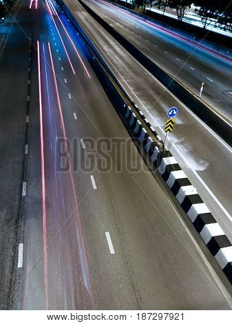 Lane Splitter on a Highway with a Sign in the Evening