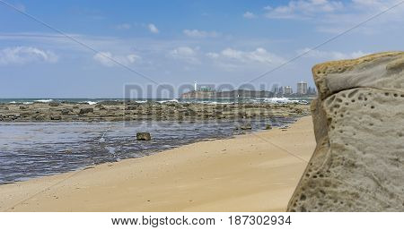Australian beach panorama with sandy foreground rocks reef crashing waves ocean horizon and blue sky