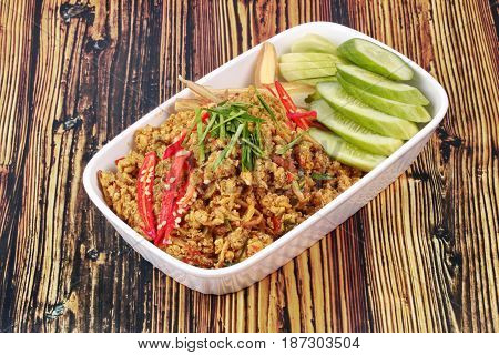 Thai southern traditional styleSpicy roasted mince chicken with yellow curry pastecall Khua Kling in Thaitopped sliced chilicucumber and correspondentsfried hot southern chilli paste with chicken
