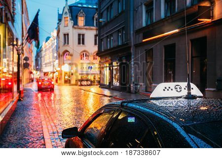 Taxi Car Wait Clients Near Cafe In Old European Streets In Rainy Evening. Night Street Illuminations.