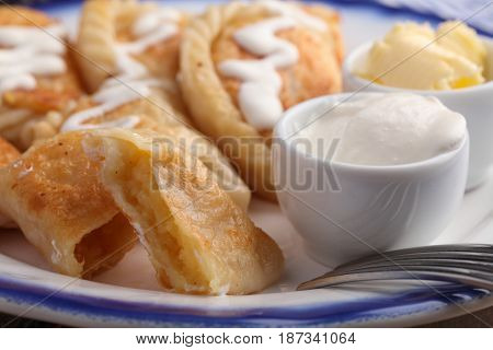 Traditional Polish dumplings Pierogi ruskie with potato, sour cream and butter on a rustic table