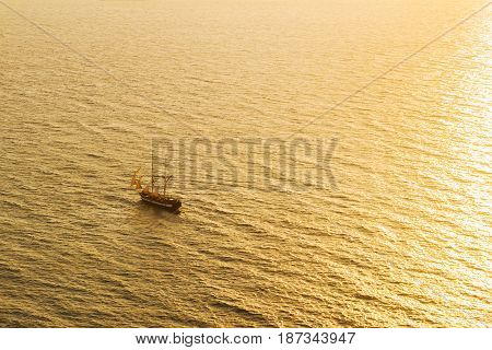 Sunset over Aegan sea and saling ship, top view