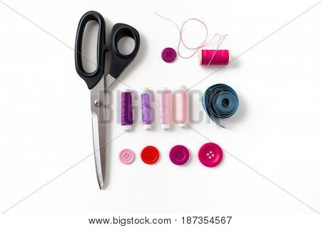 needlework and tailoring concept - scissors, sewing buttons, spools of thread and tape measure
