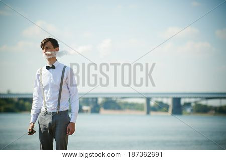 Young Skinny Man, Elegantly Stylishly Dressed In White Shirt, Trousers With Suspenders And Bow Tie.
