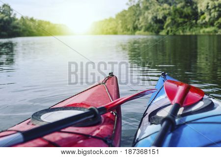A man rafts on a kayak on the river in a sunny day.