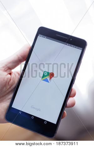 ST. PETERSBURG, RUSSIA - APRIL 19, 2017: Man holding smartphone with opening Google Maps application. First released in 2008, now the Google Maps app is used on millions mobile devices