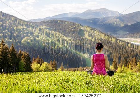 Young people sitting on a mountaintop. The concept of a healthy lifestyle travel and yoga.
