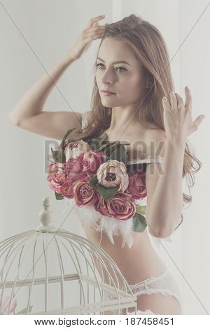 Sweet girl in her underwear adjusts her hair. Bra of flowers. Spring mood. Soft focus.