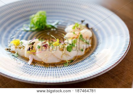 Raw scallops sashimi seafood dish. Fresh raw scallops sashimi dish. Sashimi is a Japanese cuisine delicacy consisting of sliced raw meat (usually fish and seafood) often served in sushi restaurants.