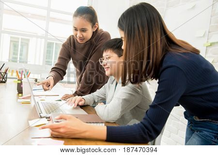 Group of university students looking at laptop computer - learning and education concept