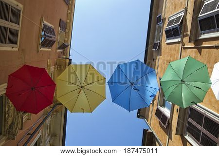 umbrellas of different colors over the street with blue sky as background