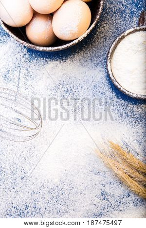 Fresh Eggs In A Bowl, Eggbeater, Wheat On Flour Background. Top View. Copy Space.