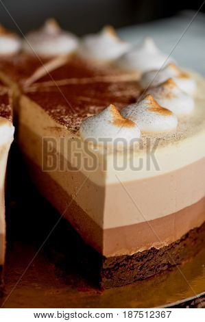 four layer cake with shades of brown. Here cream to chocolate.