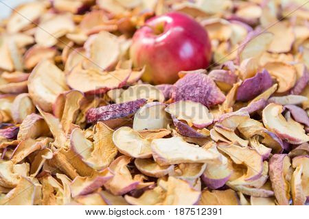 Ripe red Apple lying on a pile of dried fruit