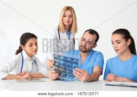 Team of doctors exploring roentgenogram at meeting