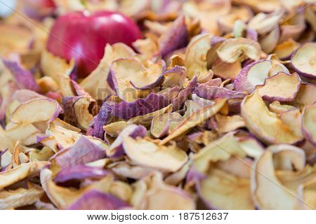 Ripe red Apple lying on a pile of dried fruit