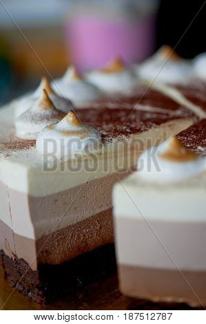 four layer cake with shades of brown. Here cream to chocolate.