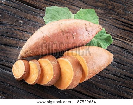 Sweet potatoes on the old wooden table.
