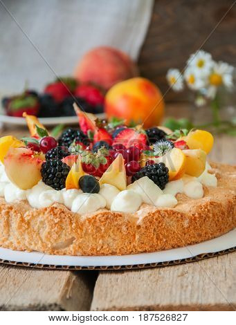 Homemade Dacquoise Cake With Wipped Cream Cheese Garnished With Summer Berries And Peaches, Close Up