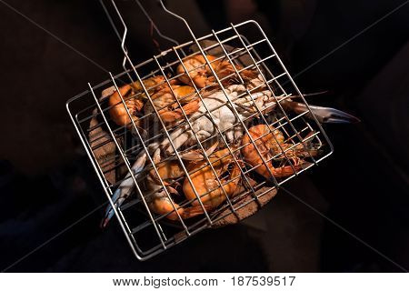 Grilled flower crabs and shrimps on charcoal stove camping at campfire.