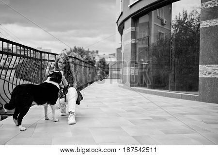 Trendy Girl At Glasses And Ripped Jeans With Russo-european Laika (husky) Dog On A Leash, Against Bu