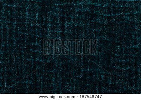 Dark green fluffy background of soft fleecy cloth. Texture of cyan plush furry textile closeup.