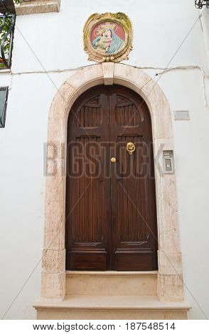 Wooden door with religious symbol. Locorotondo. Puglia. Italy.