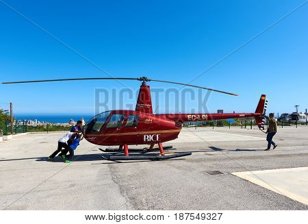 Benidorm Spain - May 13 2017: People and helicopter on a landing field. Benidorm helicopter tour is a tourist attraction on the Costa Blanca. Province of Alicante. Spain