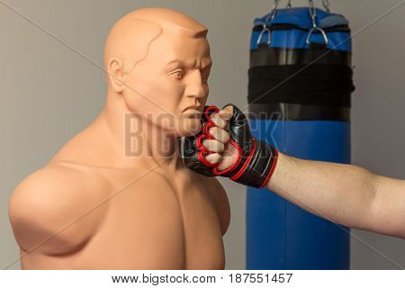 Caucasian Mma Fighter Wearing Red Mix Martial Arts Open Fingers Gloves Punching Straight On A Dummy