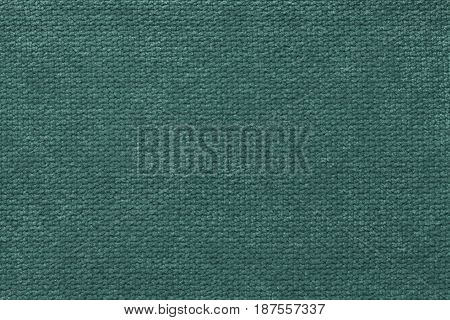 Dark green background of soft fleecy cloth. Texture of light dark cyan nappy textile closeup.