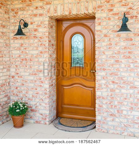 entrance of a home - stylish wooden front door in a detached house - embedded in a brick wall