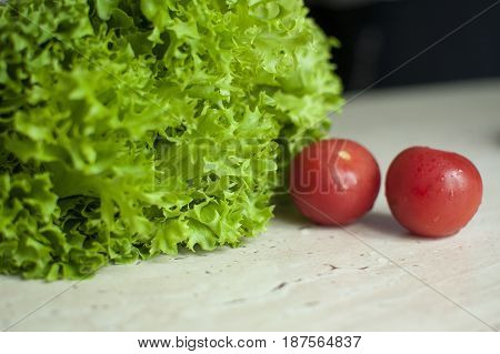 Bunch Of Raw Organic Green Frisee Salad And Two Tomatoes