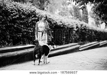 Trendy Girl At Glasses And Ripped Jeans With Russo-european Laika (husky) Dog On A Leash, Against St