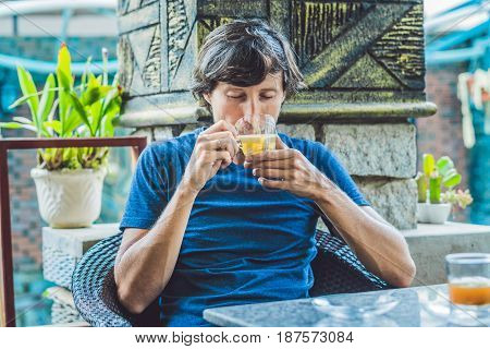 Young Man Sitting In A Cafe Drinking A Delicious Morning Ginger Tea In A Cafe