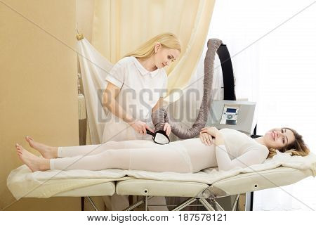 Beautiful young girl on anti-cellulite massage in the cabinet of cosmetology