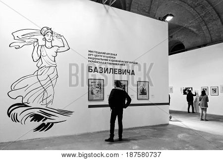 KIEV - UKRAINE - MAY 2017:  Art and book exhibition in Arsenal museum in Kiev. A man views the exposition of the exhibition. Black and white photography