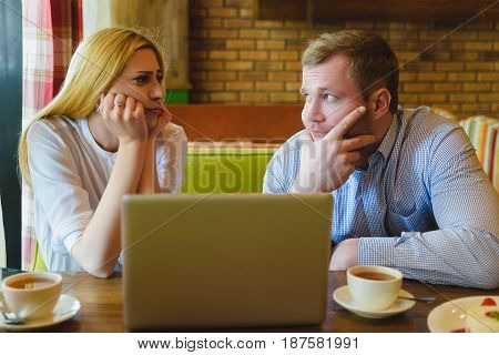 Man and woman Looking at the laptop. They are saddened and distressed.
