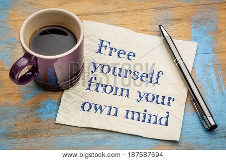 Free yourself from your own mind - inspirational handwriting on a napkin with a cup of espresso coffee